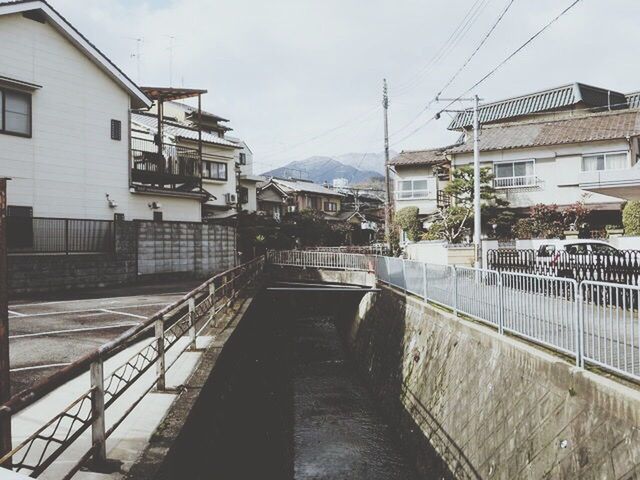 architecture, built structure, building exterior, the way forward, residential structure, sky, residential building, railing, house, diminishing perspective, city, vanishing point, connection, water, canal, building, narrow, outdoors, residential district, town