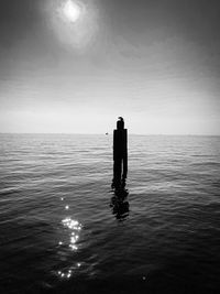 Silhouette man looking at sea against sky