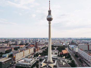 Aerial view of buildings in city against cloudy sky