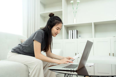 Young woman using laptop at home