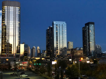 Illuminated buildings in city against sky