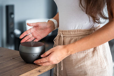 Midsection of woman making coffee at home