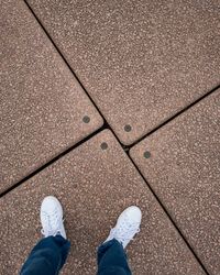 Low section of man standing on footpath