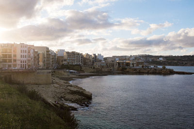 River by cityscape against sky