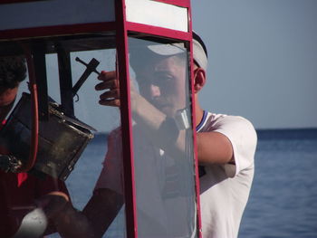 Man making popcorn using machinery at beach against sky