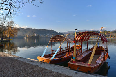 Boats moored in lake against sky