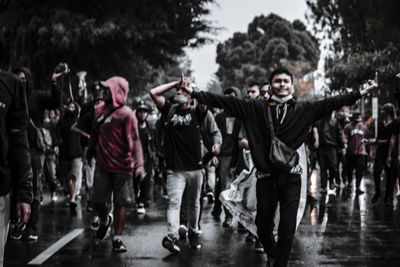 Group of people walking on wet street during rainy season