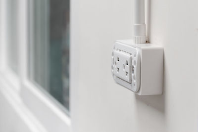 Close-up of electric outlet on wall at home