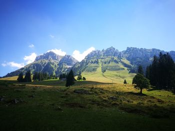 Scenic view of landscape and mountains against blue sky