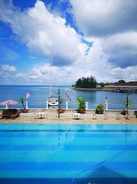 Scenic view of swimming pool by sea against sky