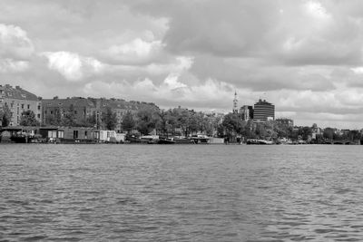 Buildings by sea against sky in city