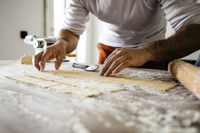 Midsection of male chef making food on table