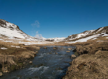 Scenic view of snowcapped mountains against blue sky