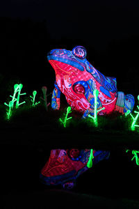 View of illuminated carousel at amusement park