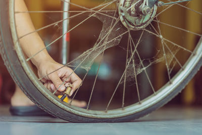 Low section of person checking bicycle wheel