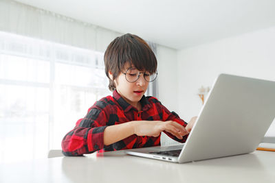 Boy using laptop at home