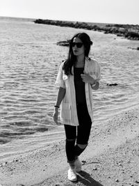 Full length of young woman standing on beach