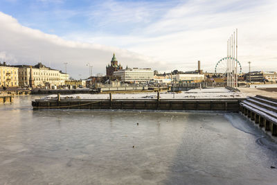 Bridge over river against buildings in city