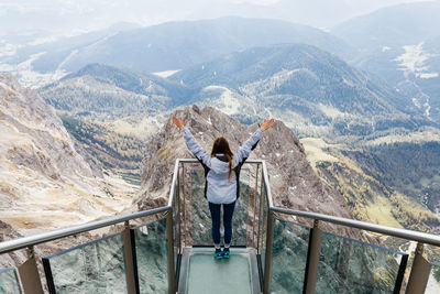 Millennial girl enjoys the views of alps from the observation deck