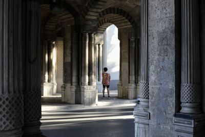 Rear view of man walking in corridor of building