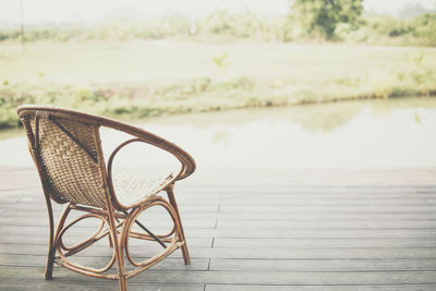 Empty chairs and table by lake