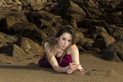 Pretty flexible blonde woman doing stretching on the beach