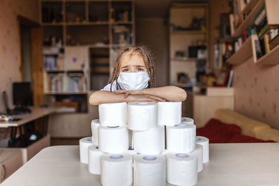 Portrait of boy sitting on table at home