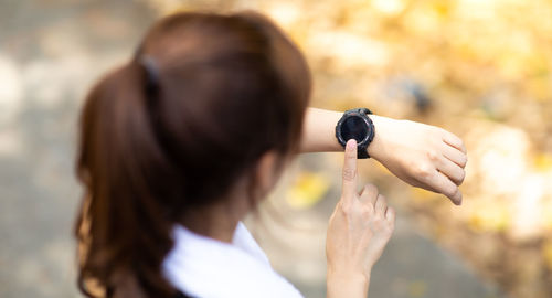 Rear view of woman holding umbrella