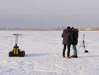 Two men standing on snow covered