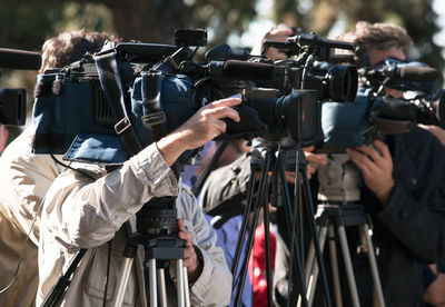 Close-up of men photographing through camera