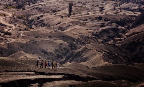 People walking in row on mountain