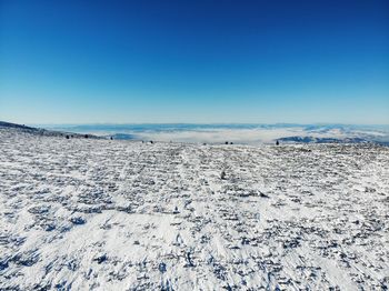 Scenic view of snowcapped landscape against clear blue sky