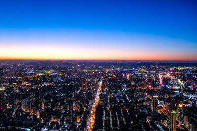 Aerial view of cityscape against sky at night