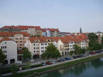 Buildings by canal against sky in city