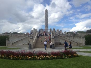 Woman looking at eiffel tower against cloudy sky