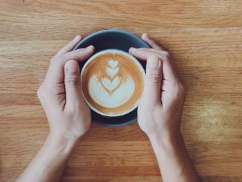 High angle view of hand holding coffee cup