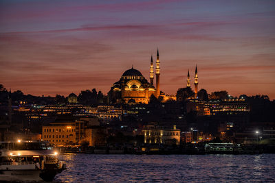 Illuminated buildings against sky during sunset