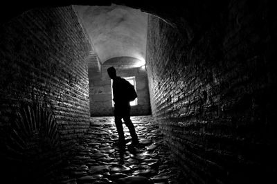 Silhouette man standing on walkway in building