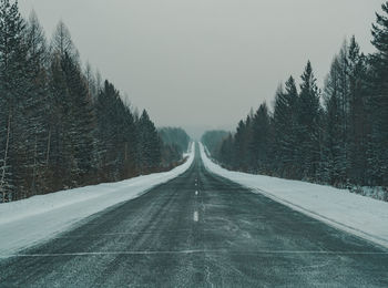 Road amidst trees against sky