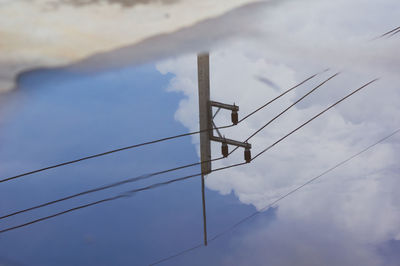 Low angle view of power lines against sky