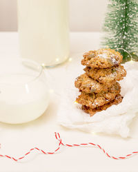 Traditional christmas cookies with cup of milk, bottle of milk on a table with holiday decoration