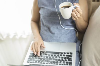 Midsection of man holding coffee cup