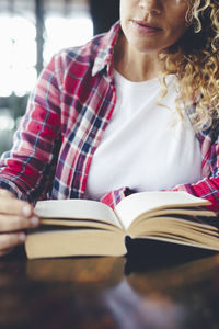 Midsection of woman reading book