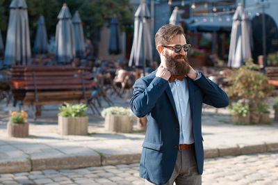 Side view of man standing against building