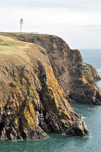 Rock formation on sea shore against sky