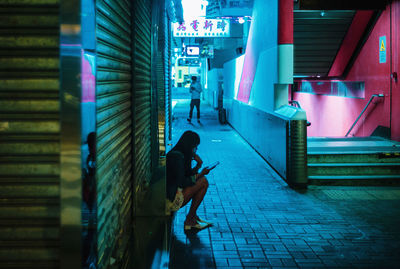 Side view of man walking on footpath at night