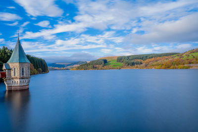 View of building in lake against sky