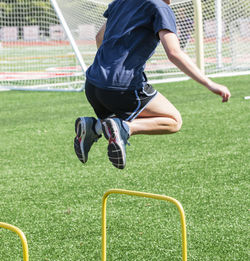 Low section of man playing soccer on field