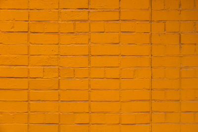 Matte orange painted brick wall full frame flat background and texture