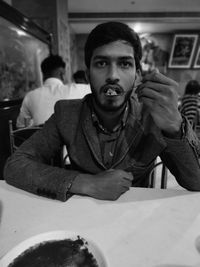 Portrait of young man sitting at restaurant